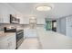 Bright kitchen with stainless steel appliances, white cabinetry, and stone countertops at 13429 Lisa Dr, Hudson, FL 34667