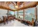 This sun room features a wood ceiling, a large fan, and many windows overlooking the backyard at 13429 Lisa Dr, Hudson, FL 34667