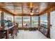 This sun room features a wood ceiling, a large fan, and many windows overlooking the backyard at 13429 Lisa Dr, Hudson, FL 34667