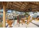 Spacious tiki hut with an outdoor dining table, grill, and comfortable seating, perfect for entertaining at 13429 Lisa Dr, Hudson, FL 34667