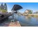 Scenic canal view featuring a boat lift, lush landscaping, and waterfront homes, perfect for boating and relaxation at 13429 Lisa Dr, Hudson, FL 34667