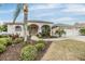 Charming single-story home featuring a well-manicured lawn, mature landscaping, and a three-car garage at 13941 Talmage Loop, Hudson, FL 34667