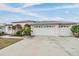 Spacious three-car garage with decorative window accents complementing the home's facade at 13941 Talmage Loop, Hudson, FL 34667