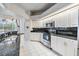 Well-appointed kitchen featuring black granite, stainless appliances, and bright white cabinetry at 13941 Talmage Loop, Hudson, FL 34667