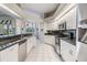 Eat-in kitchen with stainless steel appliances, dark granite counters, and bright, white cabinets at 13941 Talmage Loop, Hudson, FL 34667