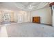 Bright and airy living room featuring neutral tones, tray ceilings, and tile flooring at 13941 Talmage Loop, Hudson, FL 34667
