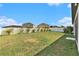 Spacious backyard with a well-maintained lawn and white picket fence, offering ample space and privacy at 14330 Fissore Blvd, Wimauma, FL 33598