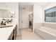 Bathroom featuring double vanity sinks, soaking tub and a walk-in shower at 14330 Fissore Blvd, Wimauma, FL 33598