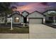 Charming single-Gathering home with a well-manicured lawn and a two-car garage at sunset at 14330 Fissore Blvd, Wimauma, FL 33598
