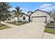 Charming single-Gathering home with a well-manicured lawn and a two-car garage on a sunny day at 14330 Fissore Blvd, Wimauma, FL 33598