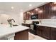 Modern kitchen with dark wood cabinets, countertops, stainless steel appliances at 14330 Fissore Blvd, Wimauma, FL 33598