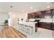 Modern kitchen with a large island, dark cabinets, and stainless steel appliances at 14330 Fissore Blvd, Wimauma, FL 33598