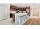 Open kitchen with a large island, stainless steel appliances, and dark wood cabinets at 14330 Fissore Blvd, Wimauma, FL 33598