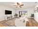 Comfortable living room with wood floors, a ceiling fan, and a sliding door to backyard at 14330 Fissore Blvd, Wimauma, FL 33598