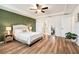 Bedroom featuring a tray ceiling, green accent wall, and wood-look flooring at 14330 Fissore Blvd, Wimauma, FL 33598