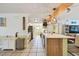 Bright kitchen with stainless steel appliances, light wood cabinets, a beamed ceiling, and an island with seating at 1468 Plateau Rd, Clearwater, FL 33755