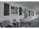 Inviting entrance with chairs and a small table, enhanced by decorative shutters and a charming lizard wall decor at 1546 Pleasant Rd # J1, Bradenton, FL 34207