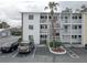 Exterior view showcasing multiple balconies, white facade, parking, and professional landscaping at 1546 Pleasant Rd # J1, Bradenton, FL 34207