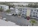 An aerial view shows the condos, parking spots, and the building's neutral tan and white exterior at 1546 Pleasant Rd # J1, Bradenton, FL 34207