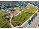 Aerial view of community park featuring playground, benches, grassy area and sidewalks at 16407 Frehley Run, Land O Lakes, FL 34638
