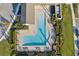 Aerial view of a community pool with blue water, surrounding landscaping, and plenty of lounge chairs for relaxing at 16407 Frehley Run, Land O Lakes, FL 34638