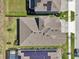 Bird's eye view of a house with a modern roof design and lush backyard landscaping and screened-in pool at 16407 Frehley Run, Land O Lakes, FL 34638