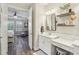 Elegant bathroom featuring a vanity with makeup area, decorative shelves, and a view of the bedroom at 16407 Frehley Run, Land O Lakes, FL 34638