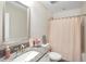 Bathroom featuring granite countertop, decorative mirror, and bathtub with a pink shower curtain at 16407 Frehley Run, Land O Lakes, FL 34638