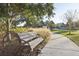 Park bench sitting on a concrete path with trees and grassy areas at 16407 Frehley Run, Land O Lakes, FL 34638