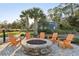 Community fire pit with Adirondack chairs on a brick paved patio and views of palm trees at 16407 Frehley Run, Land O Lakes, FL 34638