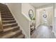 Bright foyer with wood floors, a staircase, and a decorative console table, creating a warm welcome at 16407 Frehley Run, Land O Lakes, FL 34638