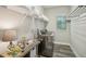 Well-organized laundry room with front load washer, wire rack, and a window with blinds at 16407 Frehley Run, Land O Lakes, FL 34638
