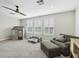 Spacious living room with carpet, a ceiling fan, big windows, and a playhouse at 16407 Frehley Run, Land O Lakes, FL 34638