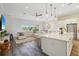 Open-concept living room with modern island, stainless appliances, and a spacious seating area with natural light at 16407 Frehley Run, Land O Lakes, FL 34638