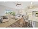 Spacious living room with a large sectional couch and expansive windows overlooking the greenery outside at 16407 Frehley Run, Land O Lakes, FL 34638