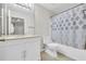 Bright bathroom features a white vanity, neutral tile floors, and a shower-tub combo with patterned curtain at 17108 Carrington Park Dr # 701, Tampa, FL 33647