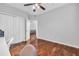 Bright bedroom featuring wood floors, a ceiling fan, and a glimpse into the living room at 17108 Carrington Park Dr # 701, Tampa, FL 33647