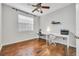 Bright bedroom featuring wood floors, a large window, and a built-in desk with stylish chairs at 17108 Carrington Park Dr # 701, Tampa, FL 33647