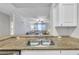 Kitchen sink with granite counters, and white cabinets overlooking the living area at 17108 Carrington Park Dr # 701, Tampa, FL 33647