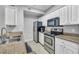 A modern kitchen featuring white cabinets, granite countertops, and stainless steel appliances at 17108 Carrington Park Dr # 701, Tampa, FL 33647