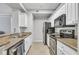 Well-equipped kitchen with white cabinetry, granite counters, and stainless steel appliances at 17108 Carrington Park Dr # 701, Tampa, FL 33647