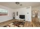 Open-concept living room with wood floors, white walls, and a view into the modern kitchen at 1777 Apache Trl, Clearwater, FL 33755