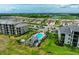 Aerial view of a community with lush landscaping, a pool, and modern condominium buildings at 17810 Gawthrop Dr # 102, Bradenton, FL 34211