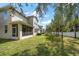 A spacious backyard featuring a screened-in porch, lush green lawn, and privacy fence at 1986 Lake Ridge Blvd, Clearwater, FL 33763
