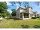 A beautiful backyard with a lawn, mature trees, and a screened lanai providing outdoor living space at 1986 Lake Ridge Blvd, Clearwater, FL 33763