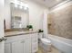 Well-lit bathroom with a granite vanity, tiled shower, and bathtub combination at 1986 Lake Ridge Blvd, Clearwater, FL 33763