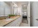 Bathroom with double sinks, granite countertop, white cabinets, and a view into the main bedroom at 1986 Lake Ridge Blvd, Clearwater, FL 33763