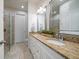 Bathroom features a double sink vanity with granite counters, white cabinets, and a shower with glass door at 1986 Lake Ridge Blvd, Clearwater, FL 33763