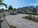 A grand gated entrance to the community with lush palm trees, greenery, and tranquil lake views at 1986 Lake Ridge Blvd, Clearwater, FL 33763