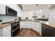 A contemporary kitchen featuring white cabinets, granite countertops, and stainless steel appliances at 1986 Lake Ridge Blvd, Clearwater, FL 33763